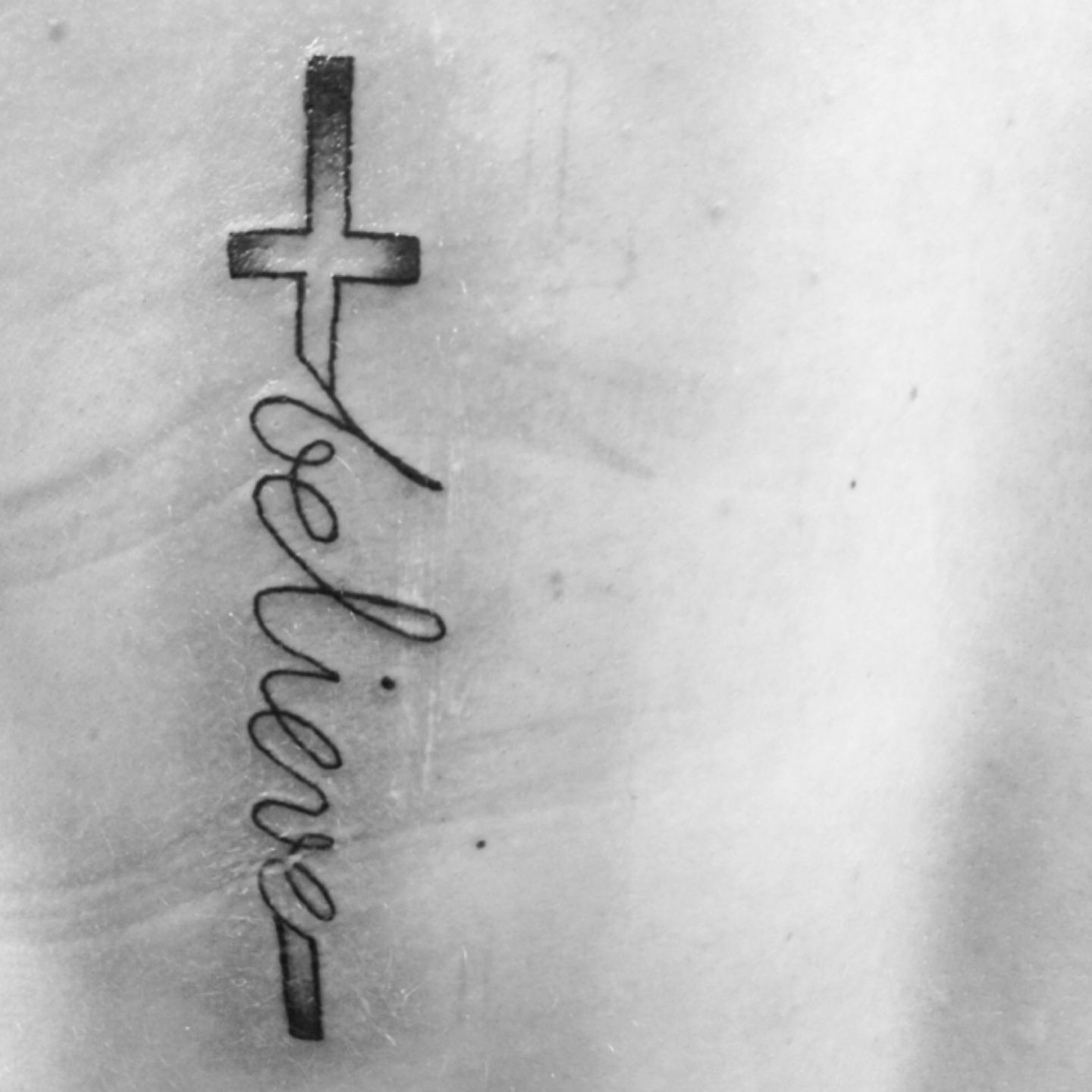 Believe tattoo with cross forearm